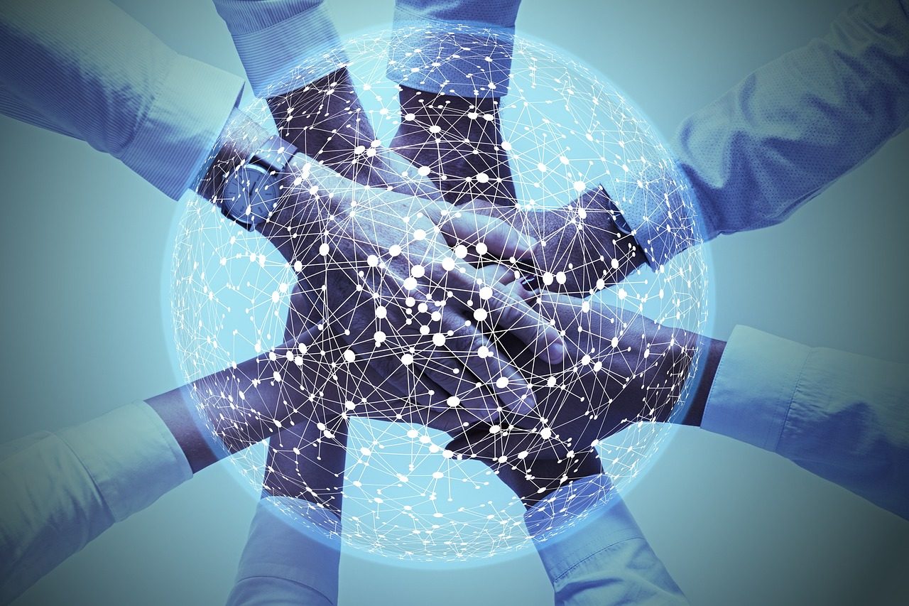 Hände universeller Vernetzung Verschmolzene Hände über einem leuchtenden, digitalen Hintergrund welcher in blau die universelle Vernetzung darstellt